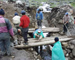 Road workers put the finishing touches to the bridge across their temporary river diversion channel