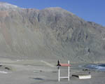 The 16th hole of Tocopilla Golf Club - tee in the box on the right, green (brown') in front of the rocks to the left