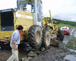 The grader came to help Mitzi, but ends up having to dig itself out